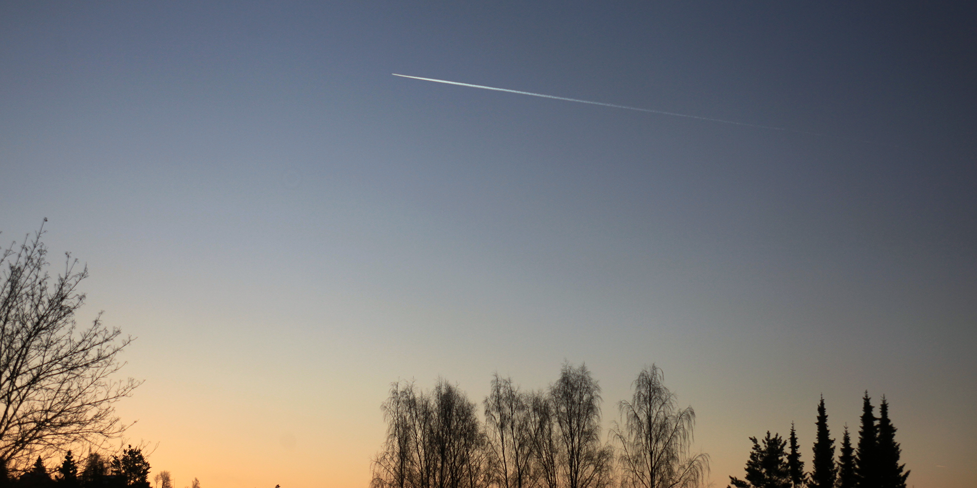 Foto av fly i lufta med hvite striper